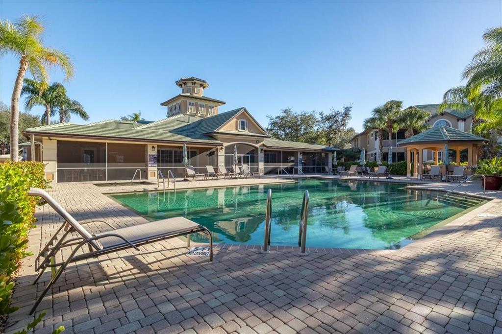 6515 Moorings Point Circle, Unit 102 Lakewood Ranch, FL 34202 - Photo 60 of 61 a front view of a house with a yard table and chairs