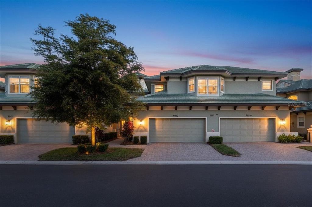 6515 Moorings Point Circle, Unit 102 Lakewood Ranch, FL 34202 - Photo 7 of 52 a front view of a house with a yard and a garage