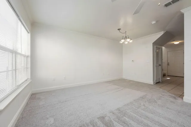 a view of staircase with railing and white walls
