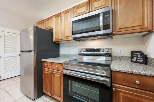 a kitchen with stainless steel appliances granite countertop a stove and a microwave