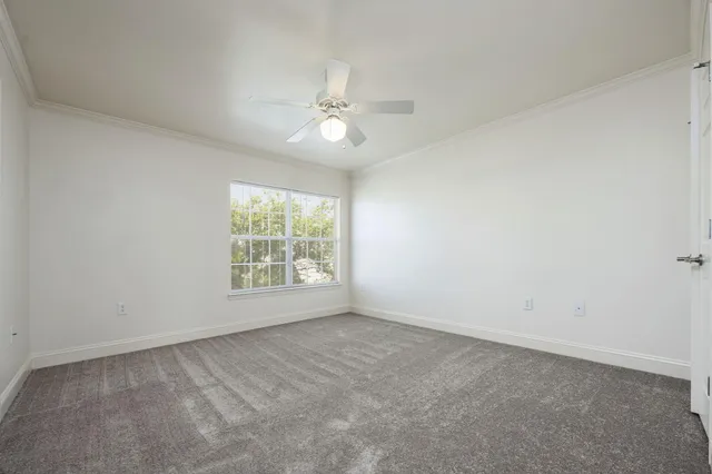 a view of an empty room and chandelier fan