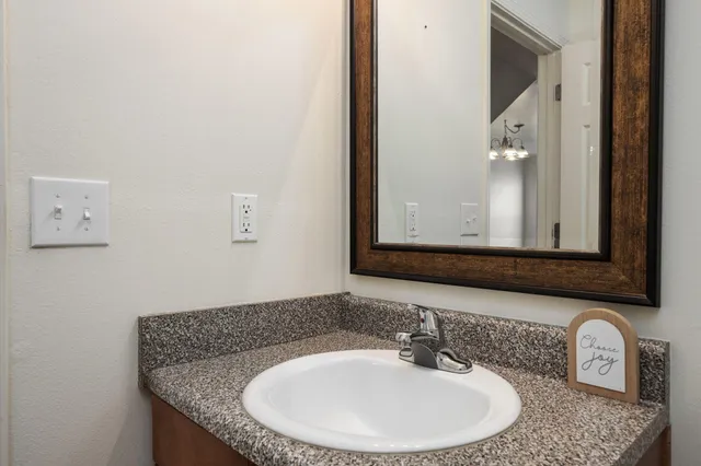 a bathroom with a granite countertop sink and a mirror