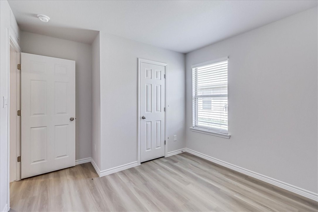1634 Comfy Way Corpus Christi, TX 78418 - Photo 26 of 39 an empty room with wooden floor and windows