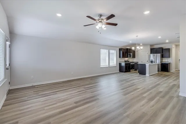 a kitchen with stainless steel appliances granite countertop a sink stove microwave and refrigerator