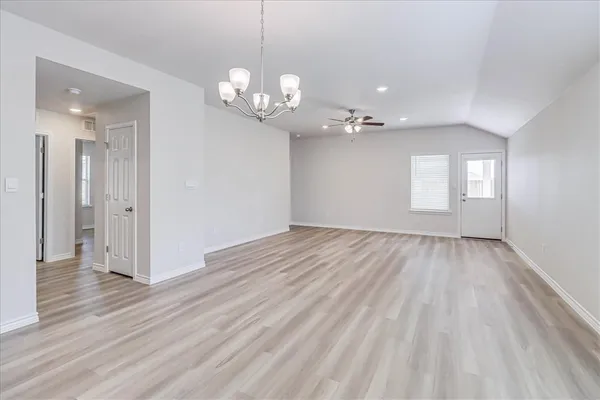 a kitchen with stainless steel appliances a stove top oven a sink a refrigerator white cabinets and wooden floor
