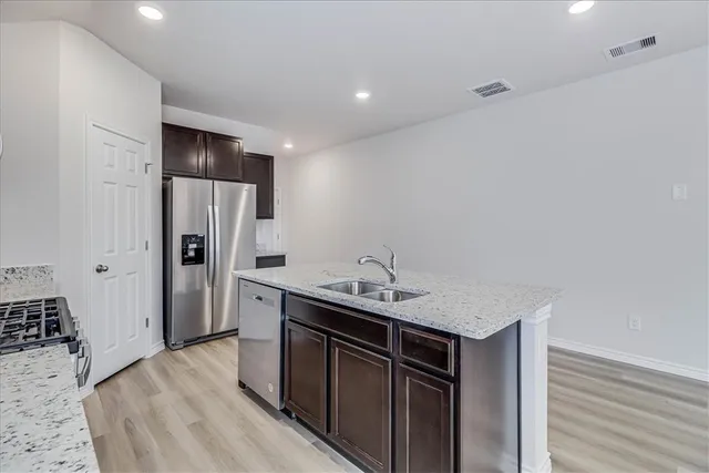 a kitchen with stainless steel appliances granite countertop a refrigerator and a sink