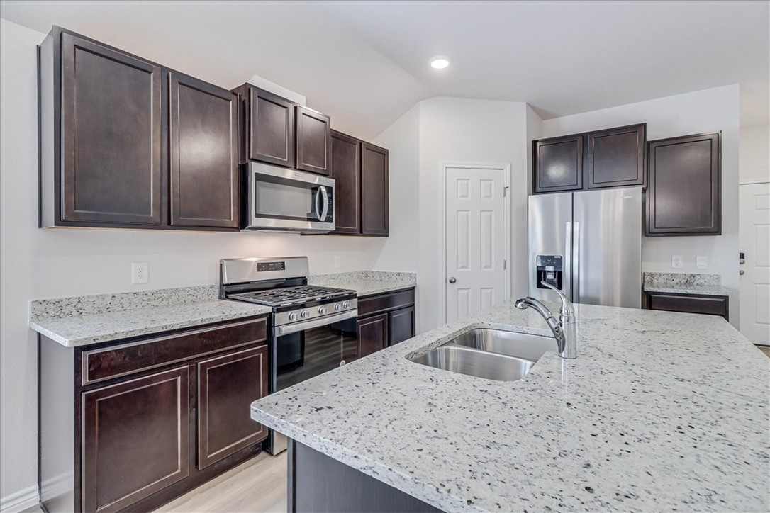 1634 Comfy Way Corpus Christi, TX 78418 - Photo 10 of 39 a kitchen with granite countertop stainless steel appliances cabinets a sink and a counter space