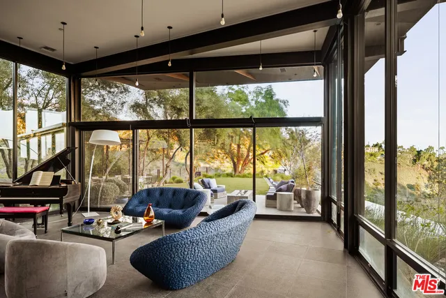 a living room with furniture and a floor to ceiling window