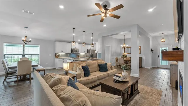 a kitchen with granite countertop a stove a sink a dining table and chairs