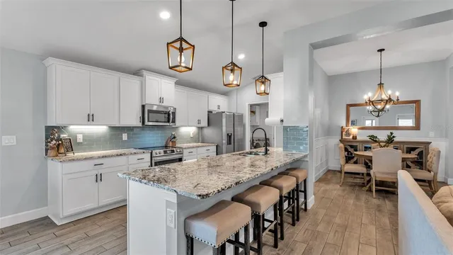 a large kitchen with granite countertop a lot of counter space and wooden floor
