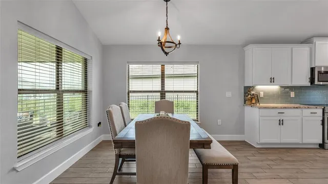 a view of a dining room with furniture a chandelier and wooden floor