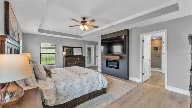 a bedroom with a large bed a chandelier and windows