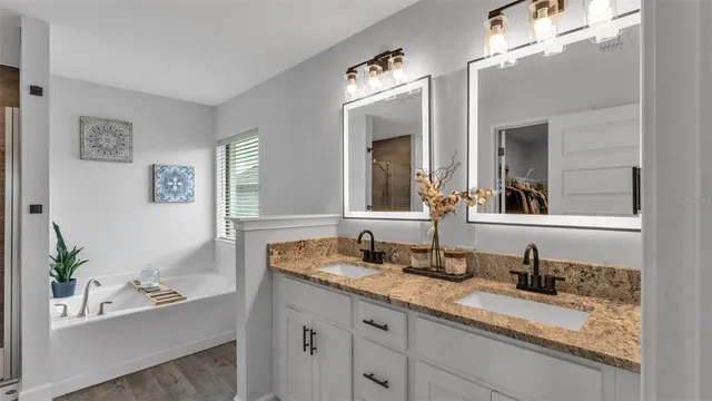 a en suite bathroom with a granite countertop sink mirror and a