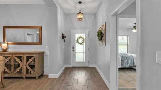 a view of a dining room with furniture a chandelier and wooden floor