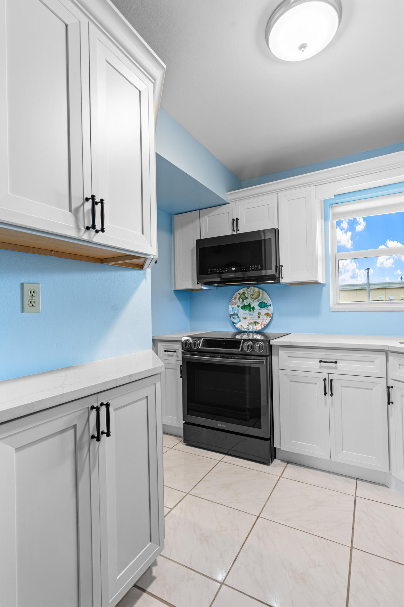 1981 Southwest Palm City Road, Unit 42H Stuart, FL 34994 - Photo 5 of 43 a kitchen with granite countertop a stove a sink and a microwave