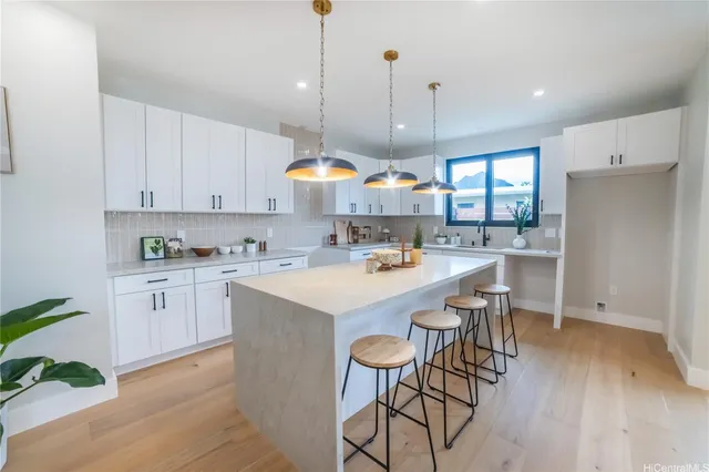 a kitchen with stainless steel appliances a table chairs sink and stove top oven