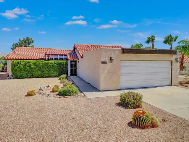 a view of a house with a yard and potted plants