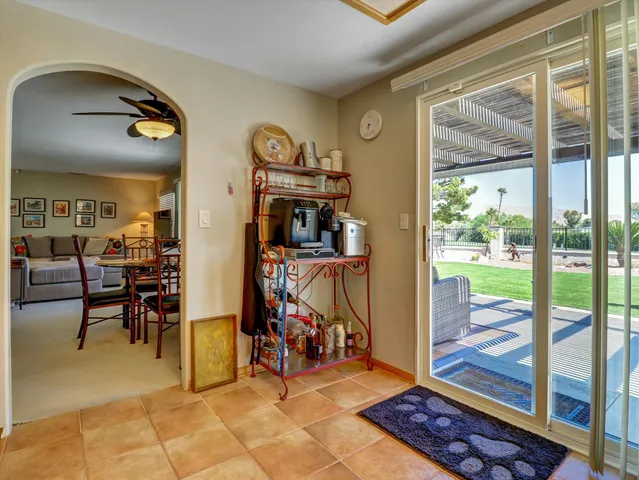 a living room with stainless steel appliances granite countertop a refrigerator and cabinets