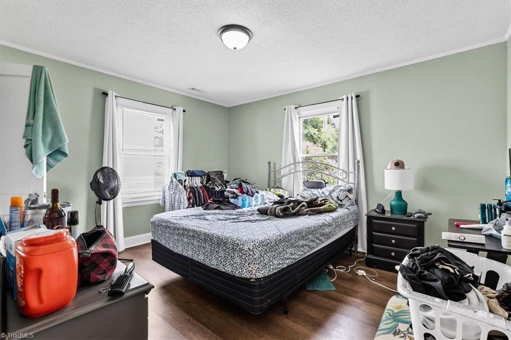 226 Friendly Avenue High Point, NC 27260 - Photo 23 of 38 The second bedroom at 226 Friendly Avenue offers comfortable proportions, natural light from two windows, and wood look flooring, currently home to one of the property's four tenants.