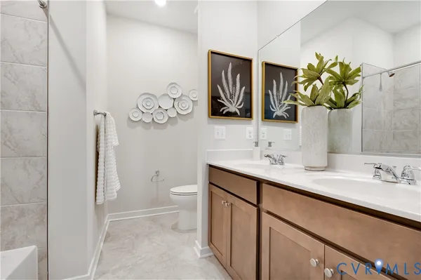 a bathroom with a toilet sink vanity and mirror