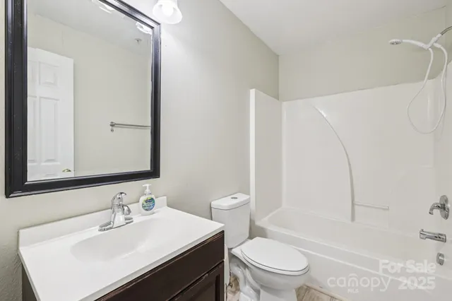 a bathroom with a sink toilet vanity and shower
