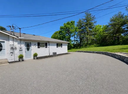front view of a house with a small yard and a large tree