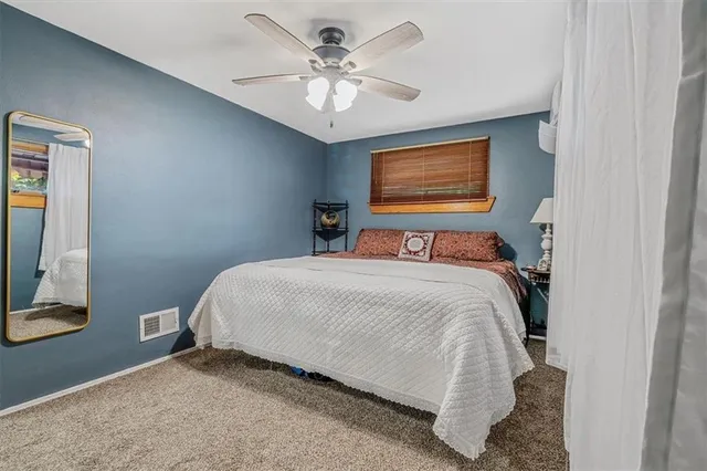 a bedroom with a bed and a ceiling fan