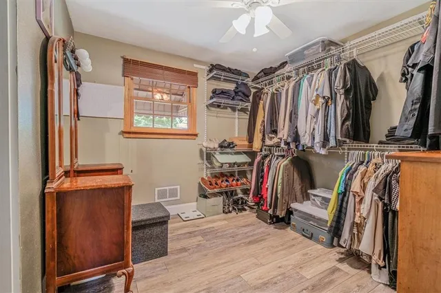 a view of walk in closet with clothes and shoes