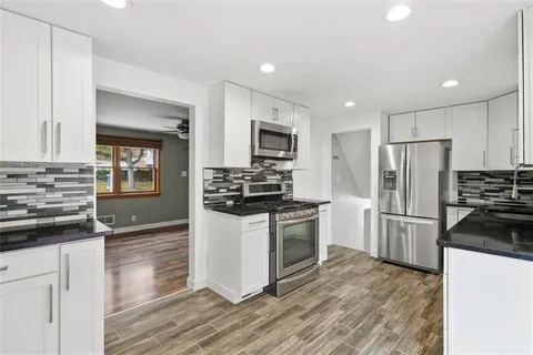 a kitchen with granite countertop a refrigerator stove and oven