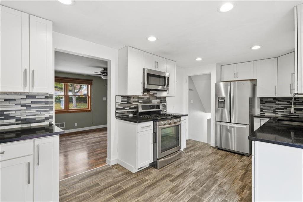 4576 Gates Drive Homestead, PA 15120 - Photo 5 of 17 a kitchen with granite countertop a refrigerator stove and oven