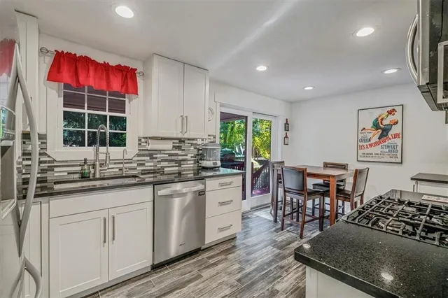 a kitchen with granite countertop a sink and cabinets