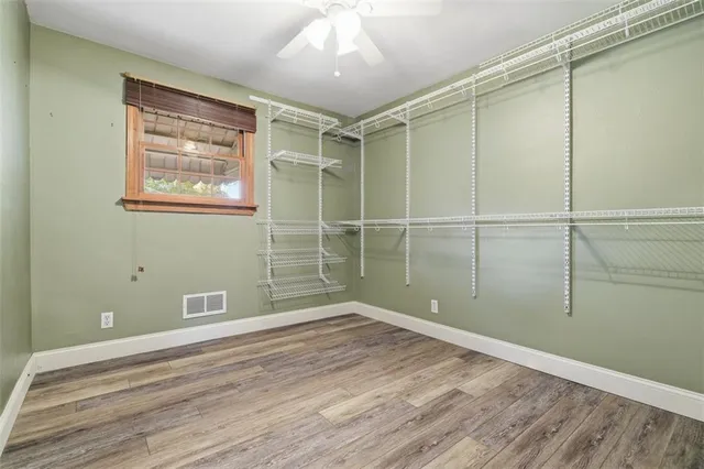 a view of a room with wooden floor and fan