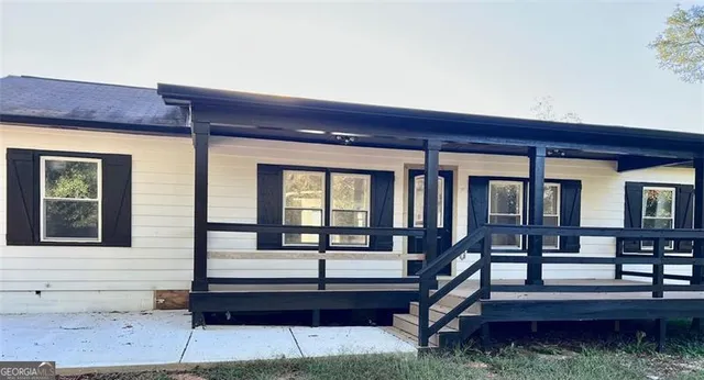 a view of a house with a small yard and wooden floor and fence