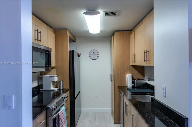 a kitchen with stainless steel appliances a refrigerator and a stove top oven