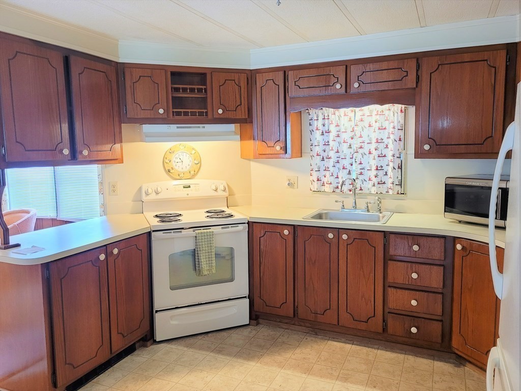 62 Longboat Road Wareham, MA 02576 - Photo 8 of 32 a kitchen with stainless steel appliances a stove a sink and a microwave