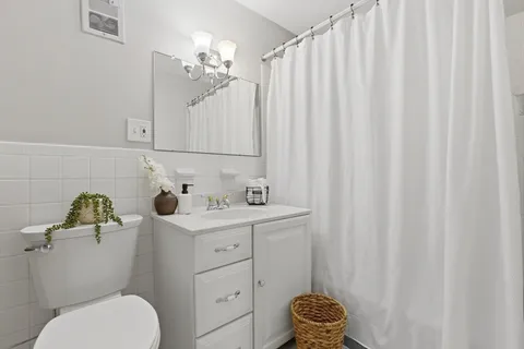 a bathroom with a sink vanity granite and toilet