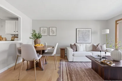 a living room with furniture wooden floor and a table