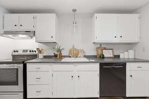 a kitchen with granite countertop white cabinets and white appliances