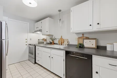 a kitchen with stainless steel appliances granite countertop a sink and cabinets