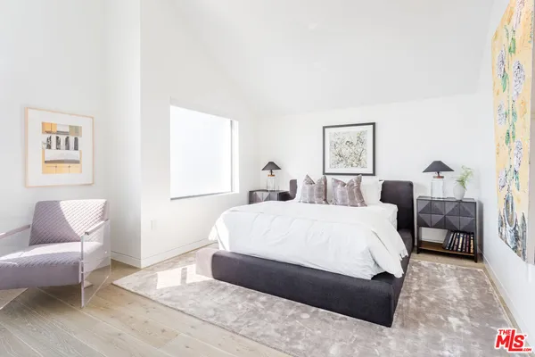 a spacious bedroom with a bed a couch and a window