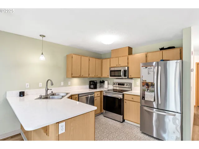 a kitchen with stainless steel appliances a refrigerator sink and microwave