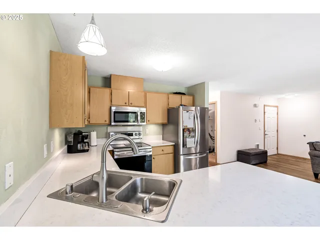 a kitchen with stainless steel appliances kitchen island granite countertop a refrigerator and a stove top oven