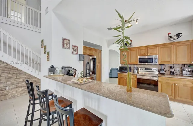 a kitchen with stainless steel appliances kitchen island granite countertop a sink and cabinets