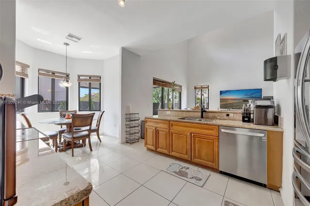 a kitchen with stainless steel appliances granite countertop a refrigerator a stove and a sink