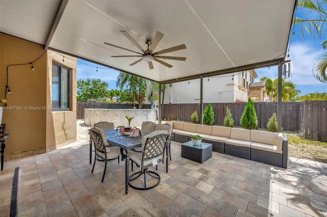 a view of a patio with table and chairs with plants and wooden fence