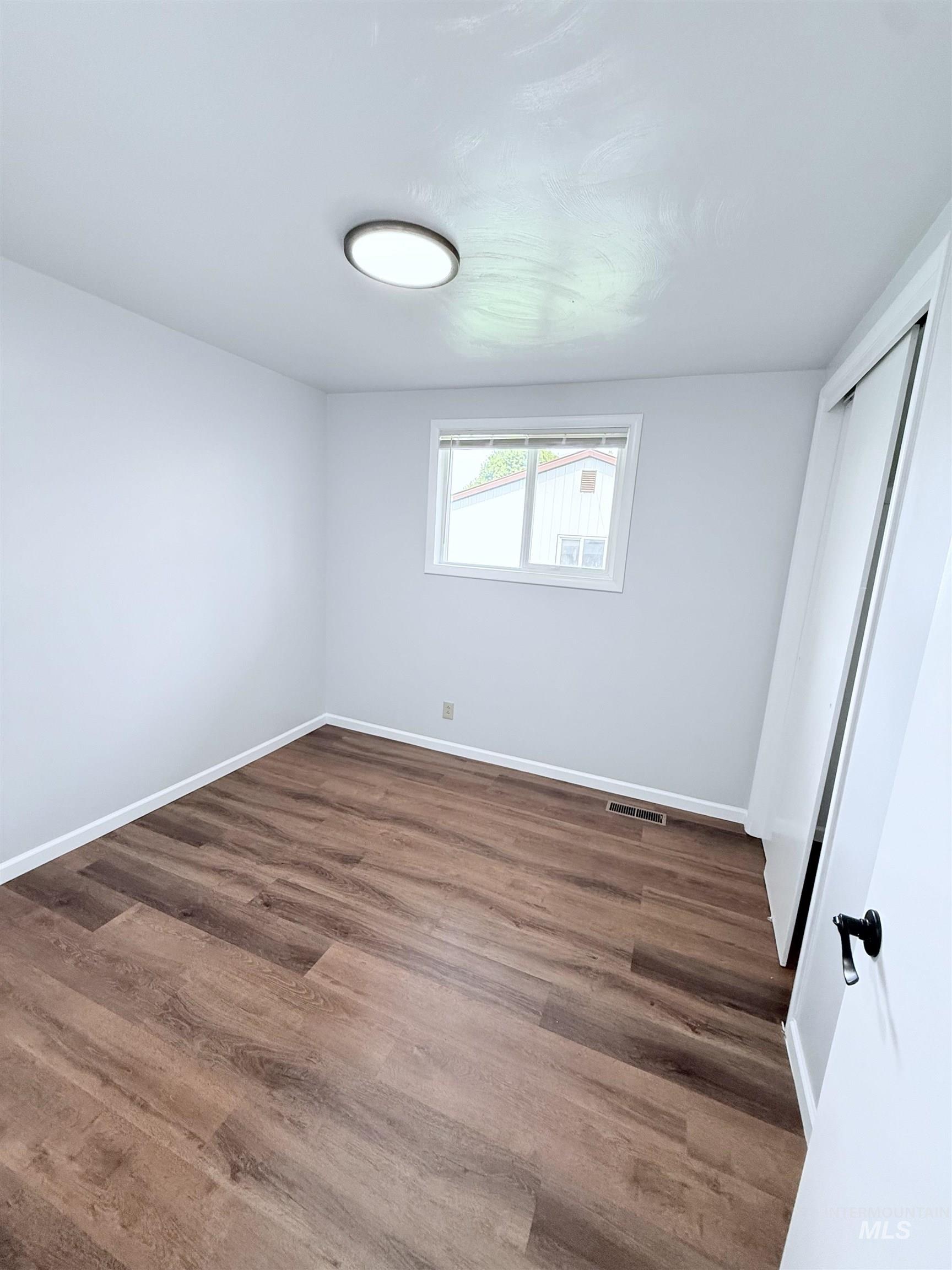 202 East Avenue Wendell, ID 83355 - Photo 11 of 24 Unfurnished bedroom with wood finished floors and a closet