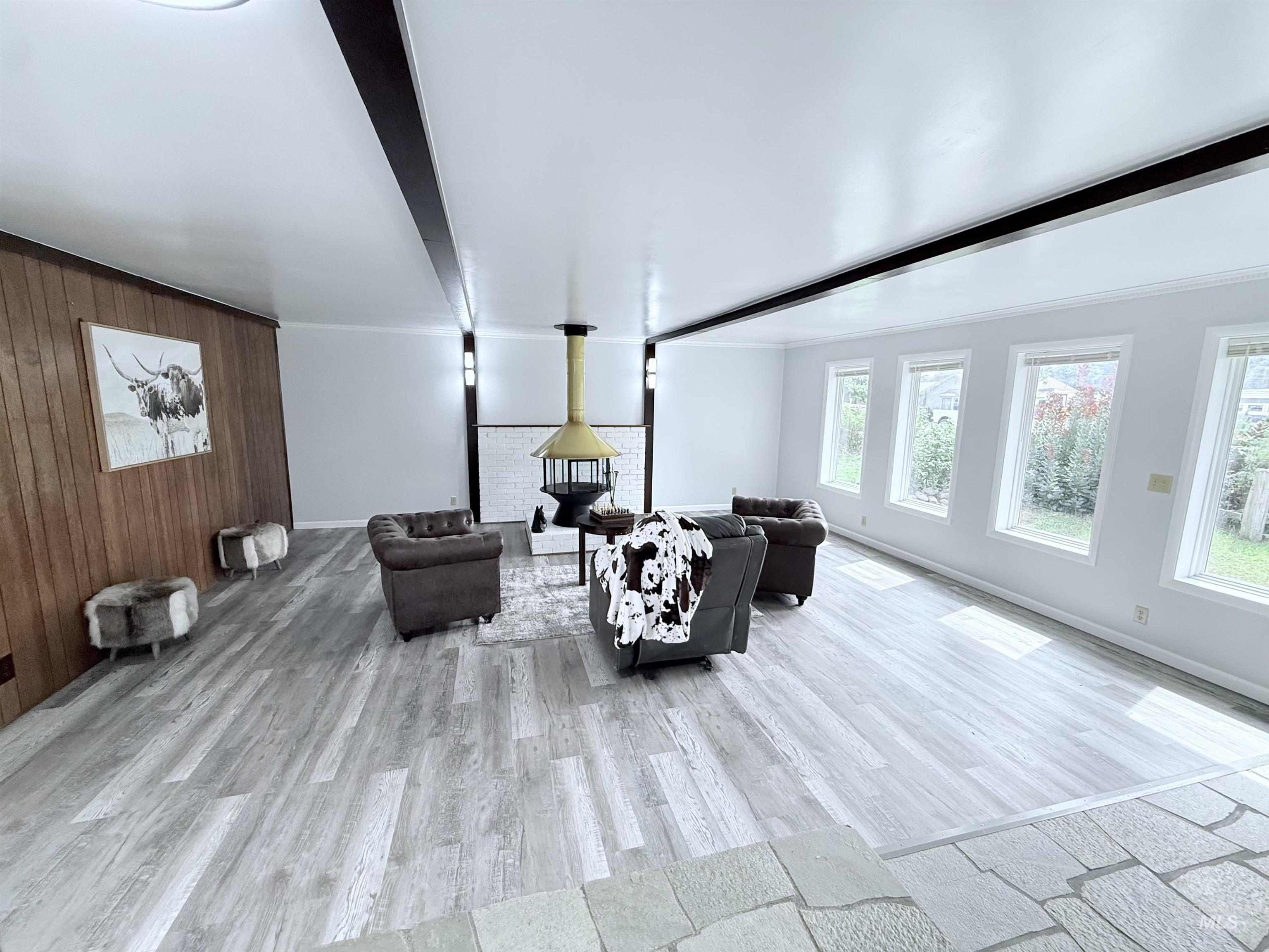 202 East Avenue Wendell, ID 83355 - Photo 14 of 24 Living area featuring beamed ceiling, light wood-style floors, wooden walls, and crown molding