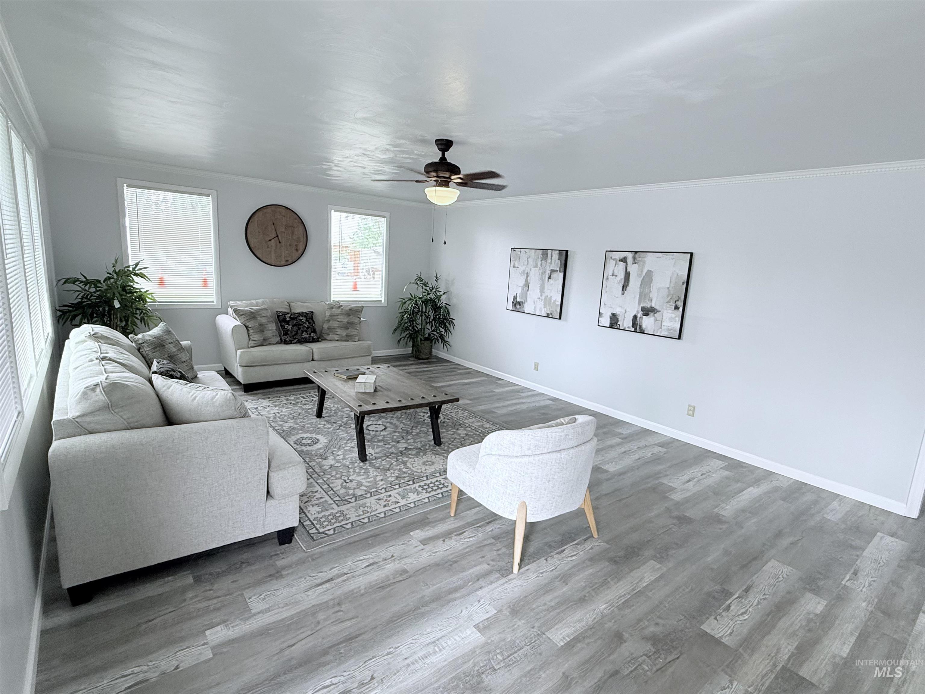 202 East Avenue Wendell, ID 83355 - Photo 2 of 24 Living room featuring crown molding, a ceiling fan, and wood finished floors