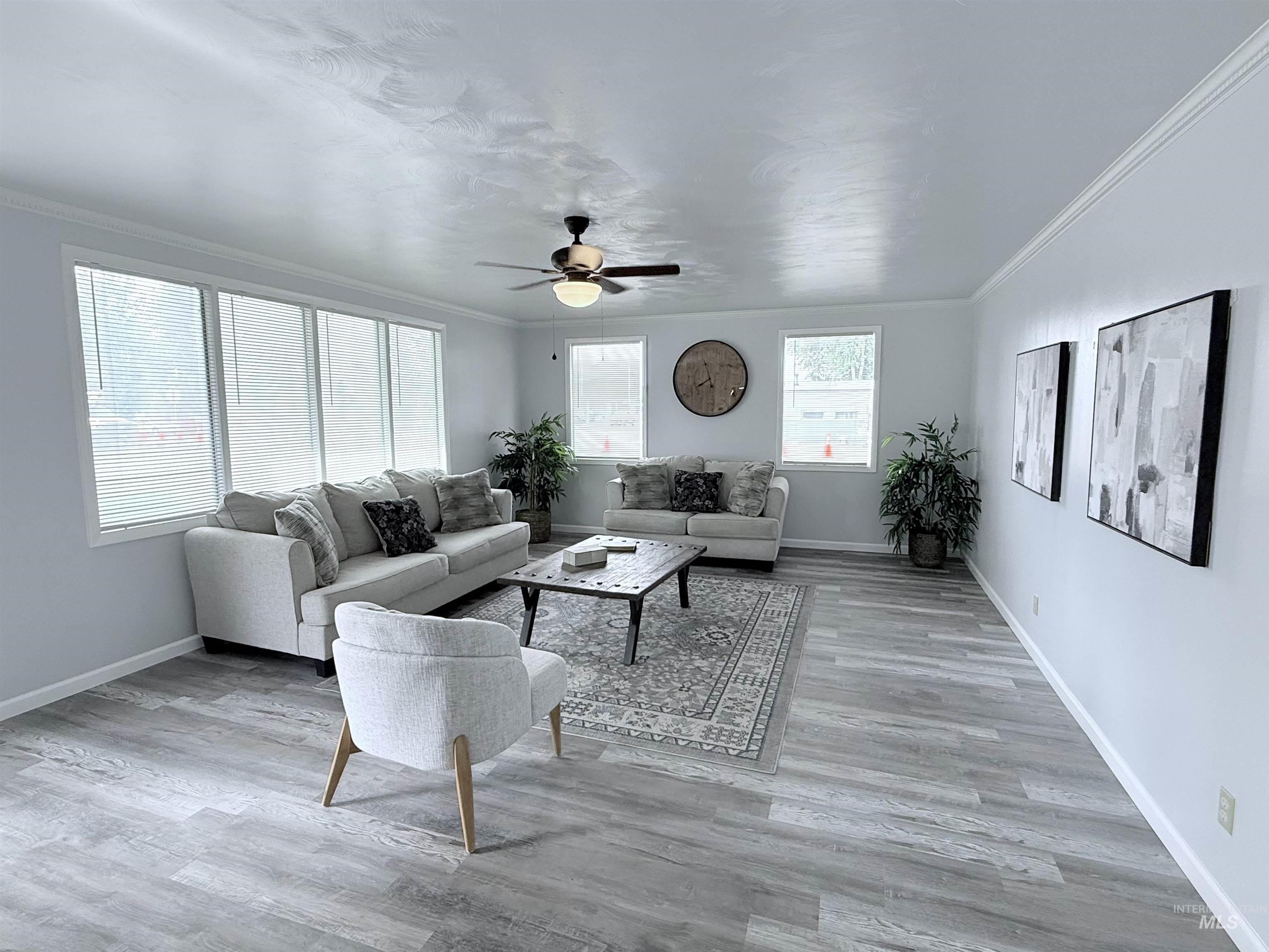 202 East Avenue Wendell, ID 83355 - Photo 3 of 24 Living room featuring crown molding, ceiling fan, and light wood finished floors