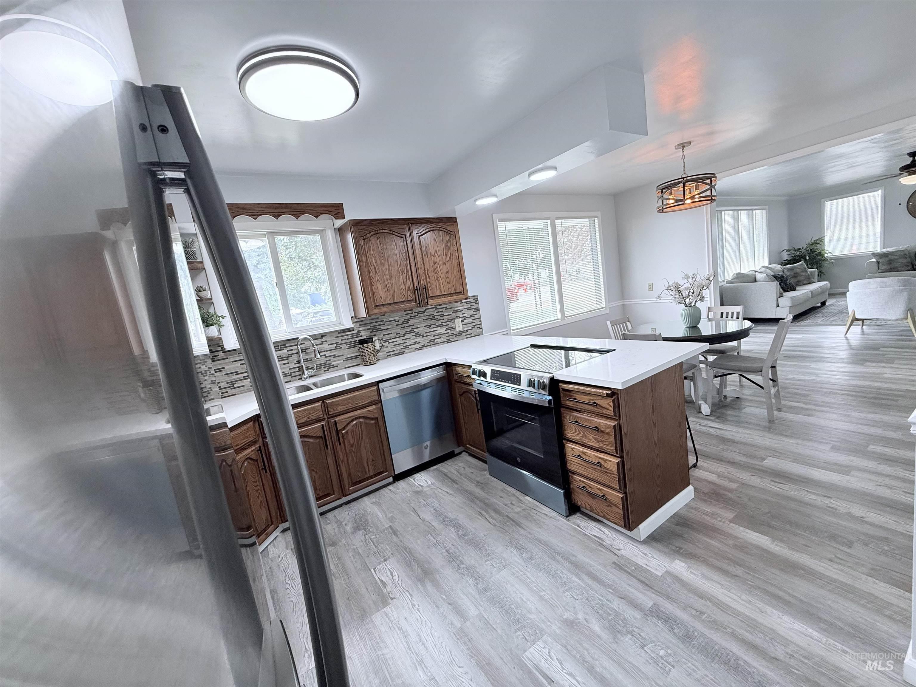202 East Avenue Wendell, ID 83355 - Photo 6 of 24 Kitchen with tasteful backsplash, stainless steel appliances, a peninsula, and plenty of natural light